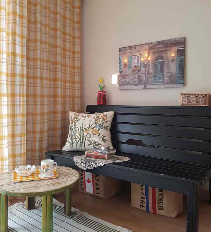 Natural-toned living room with yellow check curtains and a black bench