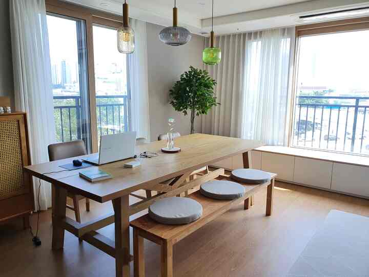 Beige and wood tone dining room featuring a wooden dining table, bench with beige cushions, creating a natural atmosphere