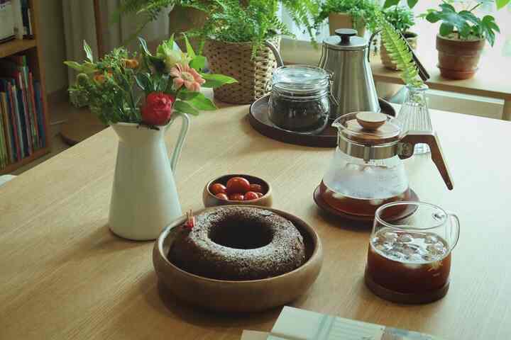 木目調のダイニングルーム、花瓶とコーヒー機器が配置された自然なホームカフェの雰囲気あるインテリア