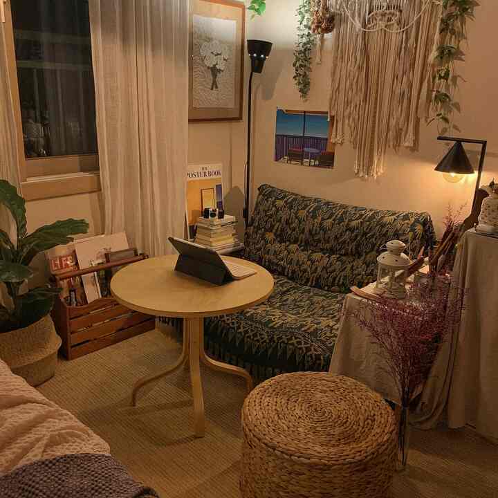 Beige and natural toned small bedroom featuring rattan stool and round table in a cozy setting