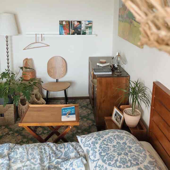 Natural-tone bedroom featuring wooden furniture and blue patterned bedding creating a cozy atmosphere