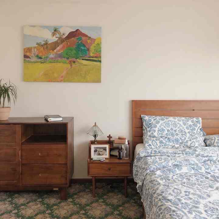 木目調の家具と白い壁が調和するミニマルな寝室、落ち着いた清潔感のある空間