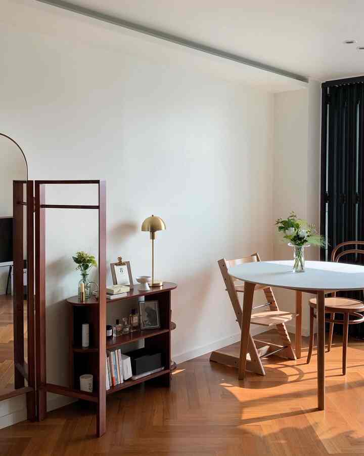 ナチュラルトーンのダイニングルーム、白い丸テーブルと木製チェアが配置された清潔感と温かみのあるインテリア