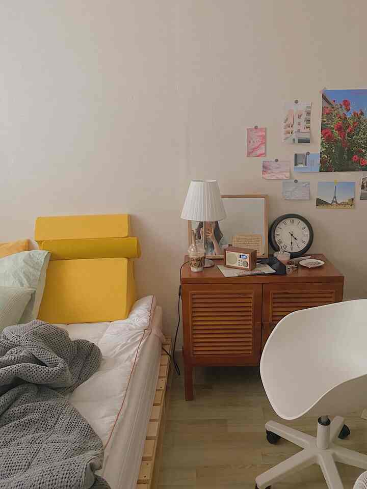 Bright wood tones and white hues in a bedroom featuring yellow cushions and simple decor creating a cozy atmosphere