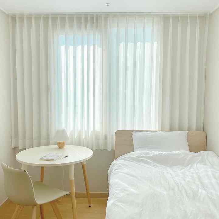A white and wood tone 6-mat bedroom featuring a round table and bed with simple and minimal atmosphere