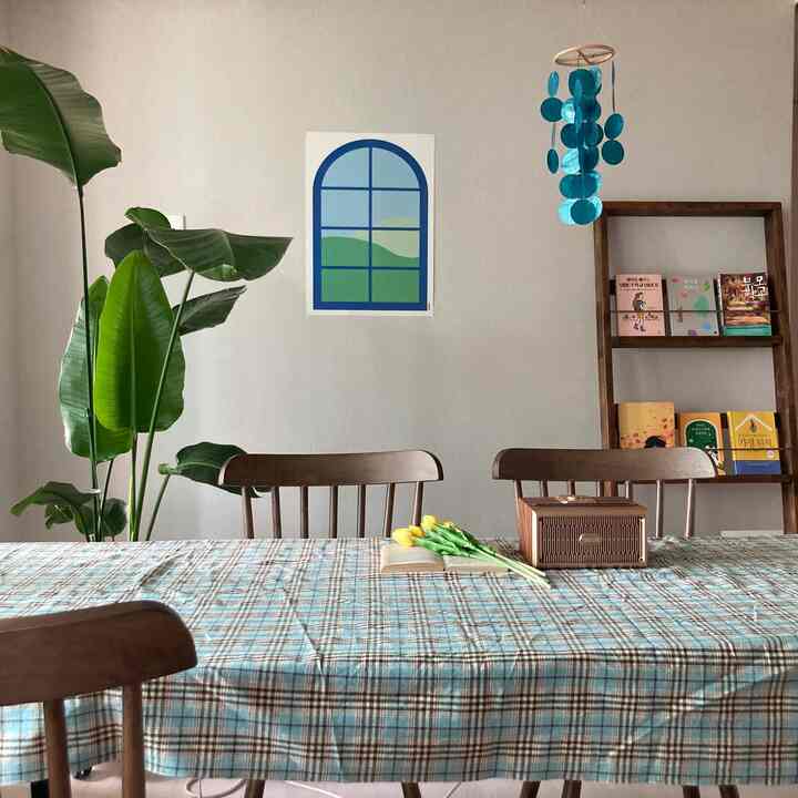 Dining room with brown and blue tones featuring wooden dining table and chairs, green plant, and wall decor creating a cozy atmosphere