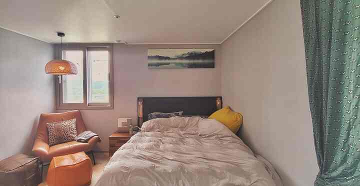 6-mat bedroom with brown leather armchair and pendant light, natural tones create a cozy atmosphere