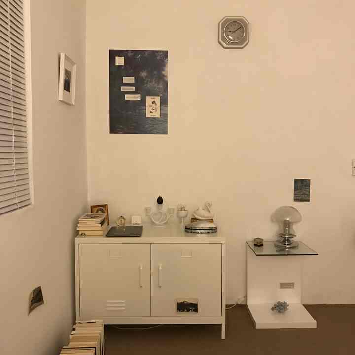 White and brown toned living room featuring minimal modern storage furniture and wall clock with clean atmosphere