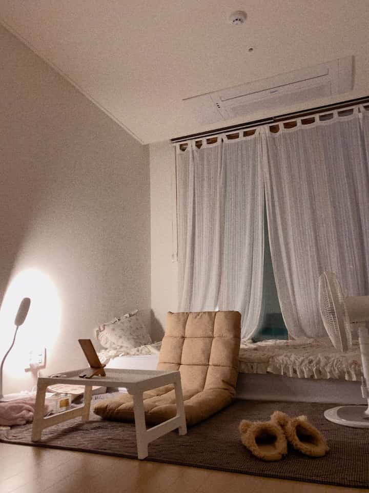 温かみのあるベージュとアイボリーの6坪ワンルーム、座椅子と低いテーブルが居心地の良い一人暮らし空間を演出しているインテリア