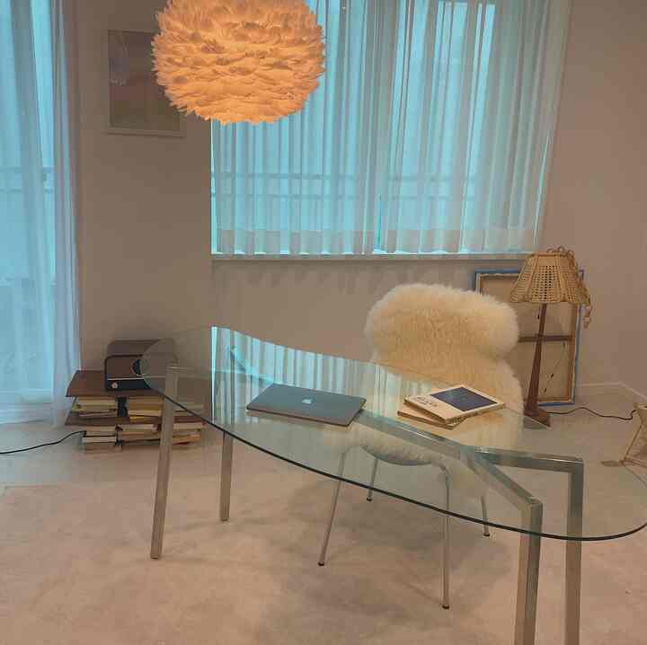 White and beige toned living room featuring a transparent glass table and modern armchair with a natural atmosphere