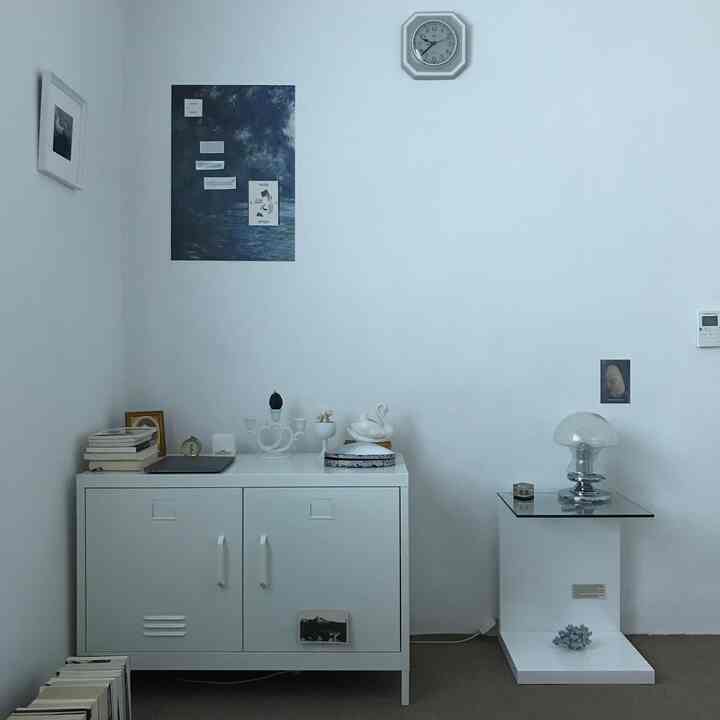 Bright white tone small room featuring a white cabinet and glass table lamp, creating a simple and minimal atmosphere