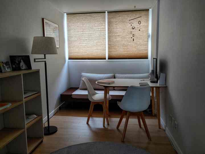 ナチュラルな木目調とホワイトが調和する狭くコンパクトな書斎、シンプルでミニマルな家具配置の空間