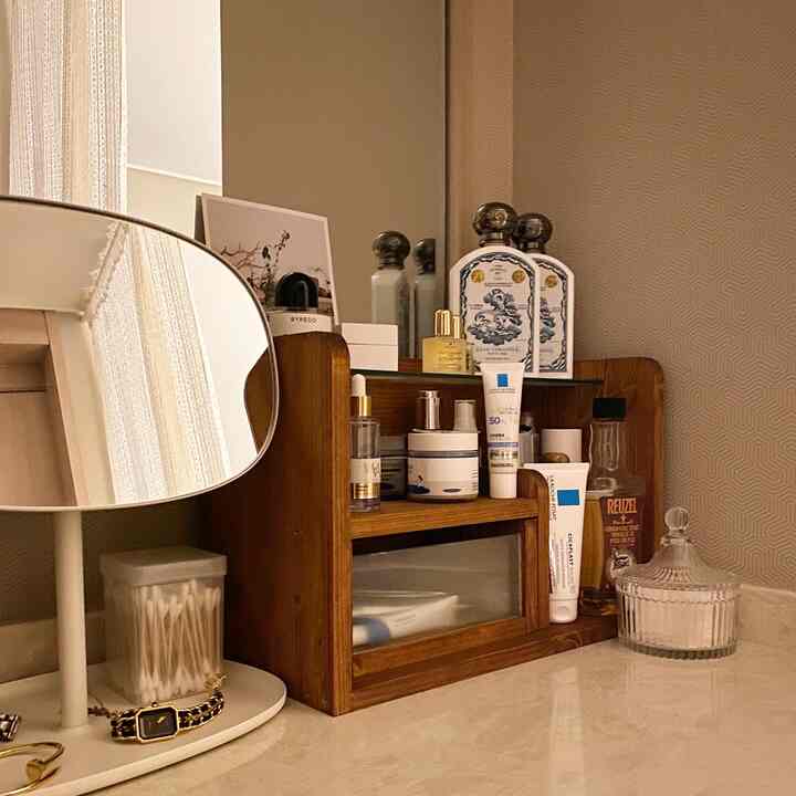 温かみのあるウッドトーンとブラウンのヴィンテージスタイルのパウダールーム、化粧台の整理箱と鏡が配置された雰囲気のあるインテリア