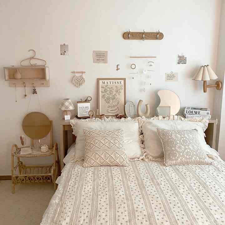 ベージュとナチュラルトーンの寝室、パターンのベッドカバーとフリル付き枕が配置された印象的な空間