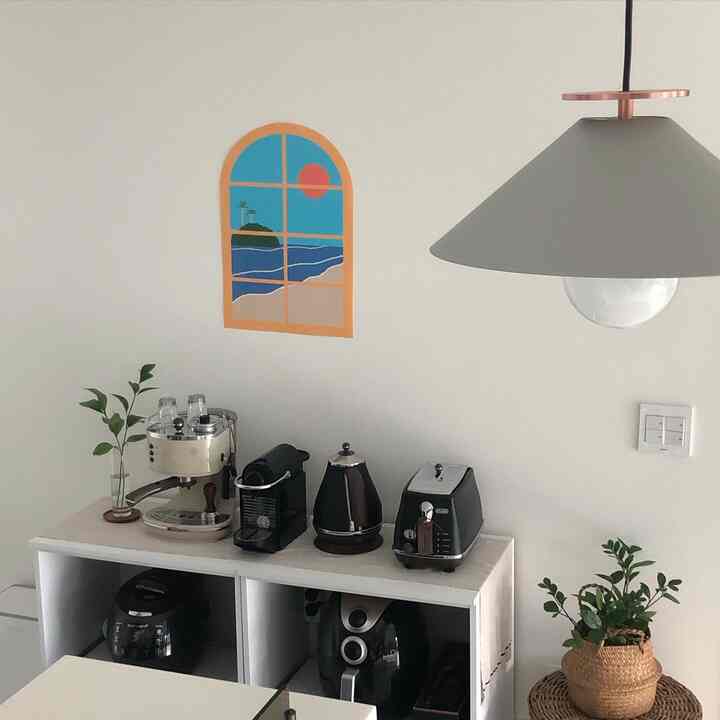 White-toned kitchen home cafe space featuring coffee machines, kettle, and toaster arranged on a counter with cozy atmosphere
