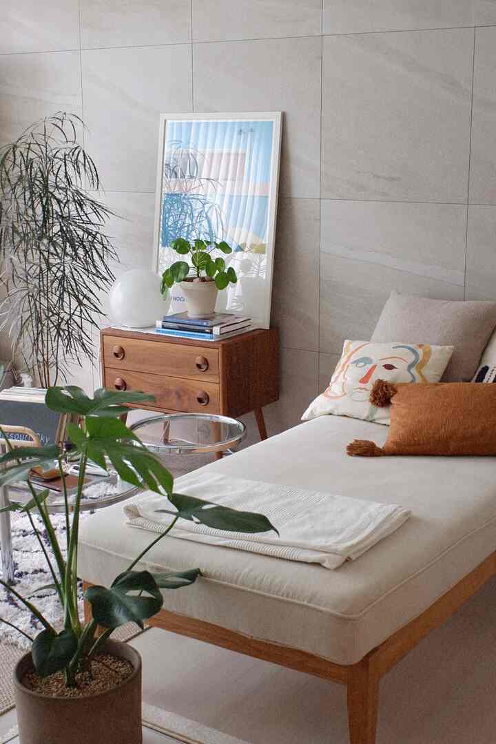 Neutral beige and wood tone living room featuring a daybed and plants with a natural and cozy atmosphere