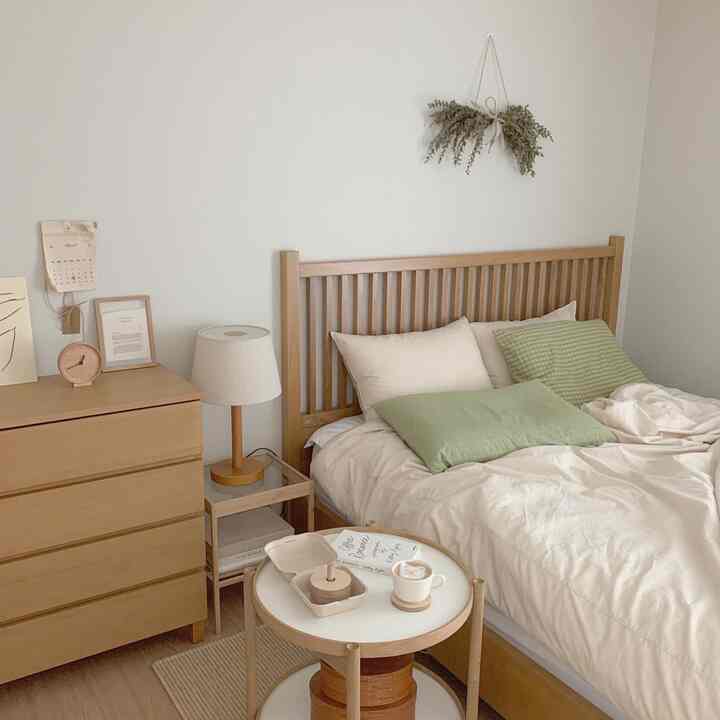 Ivory and wood-tone bedroom featuring wooden bed and nightstand with soft, natural interior atmosphere