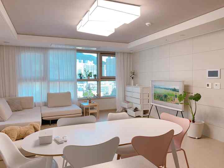 White and beige toned living room featuring a large dining table with surrounding dining chairs in a cozy space