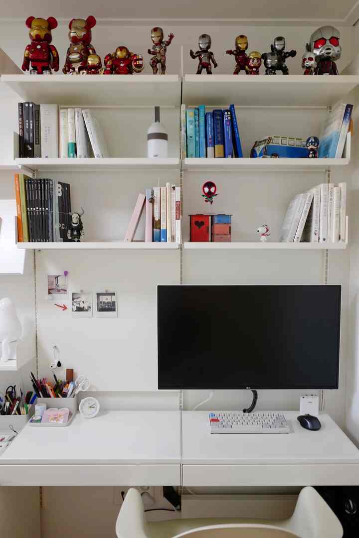 白を基調とした書斎空間、白いデスクと棚に本やキャラクター小物が整然と配置された雰囲気のあるインテリア