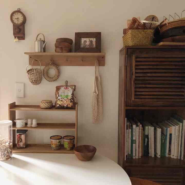 Cozy dining room featuring warm brown wood tones, rattan accessories, shelves, and a cabinet