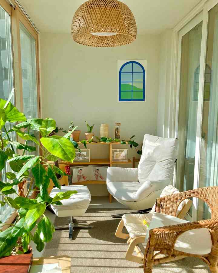 A natural wood-tone and white living room featuring large plants and cozy seating bathed in bright natural light