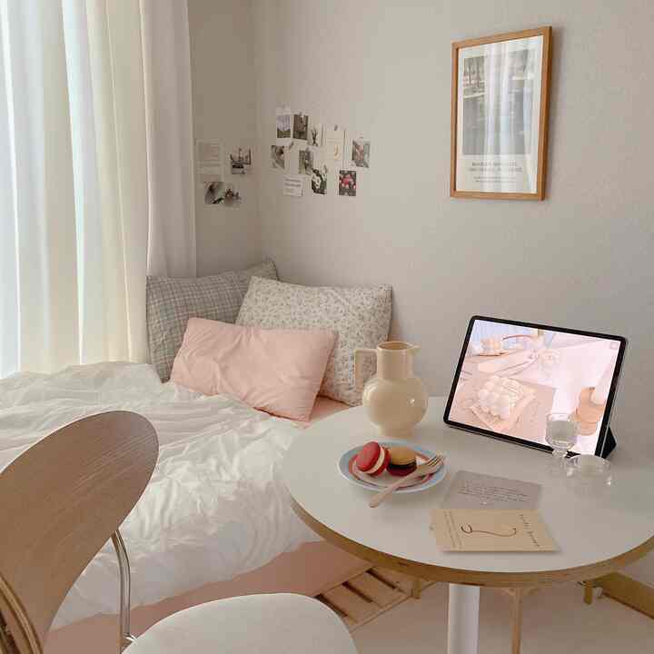 Cozy bedroom space in white and wood tones featuring bedding and cushions creating a warm atmosphere