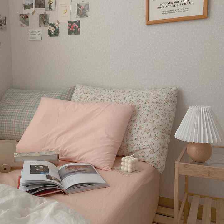 A cozy bedroom space in apricot and beige tones featuring floral and plaid pillows