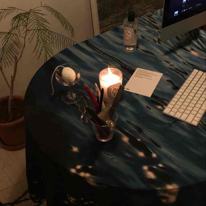 ブルートーンのデスクがある在宅勤務スペース、キャンドルとディフューザーが配置された雰囲気のあるインテリア。