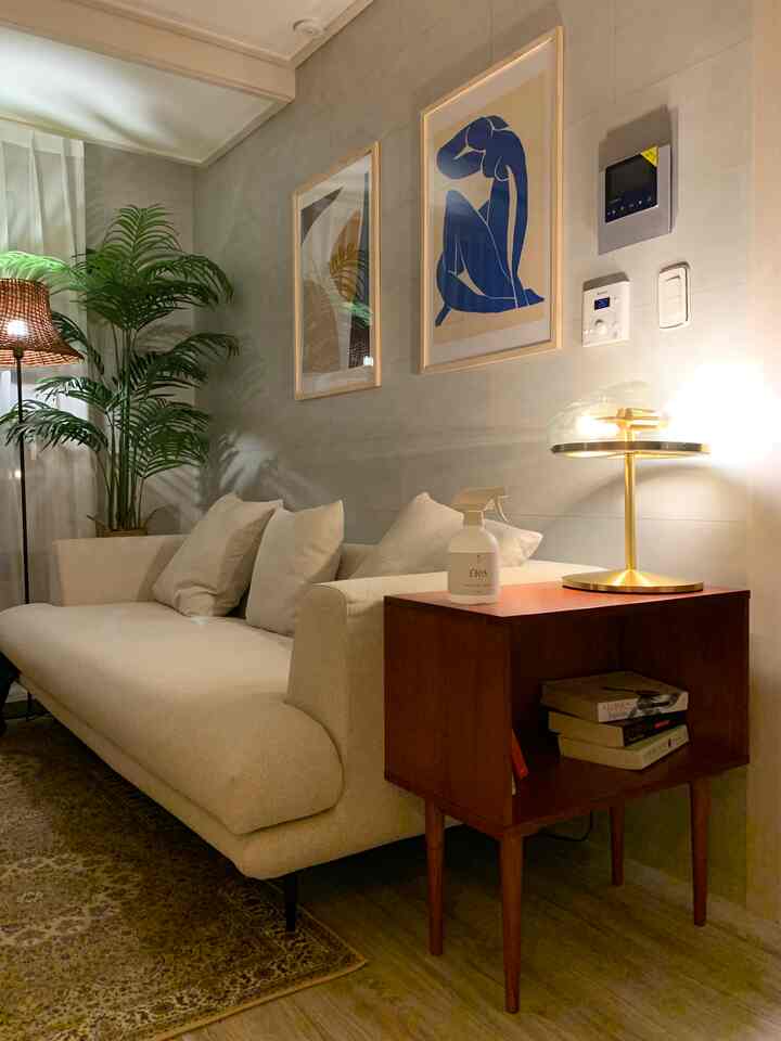 Natural tone living room featuring beige sofa, wooden side table, and an Art Deco style table lamp creating a cozy atmosphere