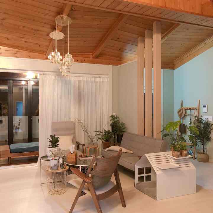 Natural wood tone ceiling living room featuring gray sofa and wooden armchair with a cozy natural vibe