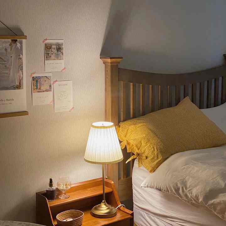 暖かいブラウンの木製ベッドと木製ナイトテーブル、白い壁と寝具が調和する雰囲気のある寝室