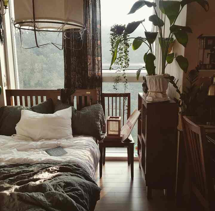 温かみのあるブラウンとグリーンのトーンが印象的なナチュラルモダンな寝室、木製家具と豊かな植物が配置された居心地の良い空間