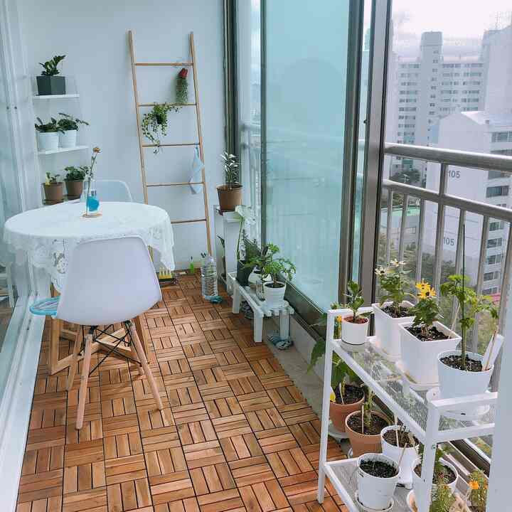 White and wood tone veranda featuring plant stands and a round table creating a natural atmosphere