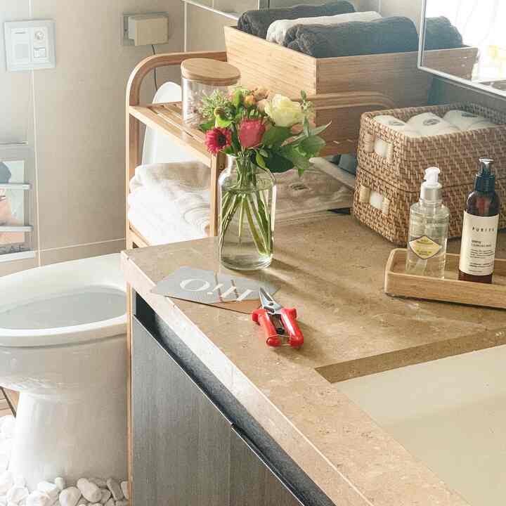 暖かい木目調とナチュラル素材が際立つ乾式バスルーム、花瓶とタオルが配置された清潔感のある印象的な空間