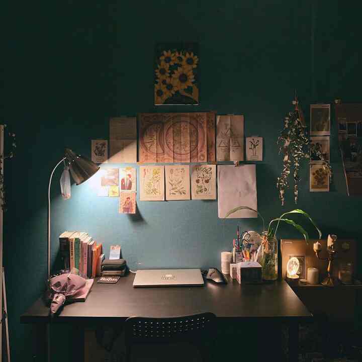 Blue-toned wall and black desk with chair in a cozy, focused single-person remote work space