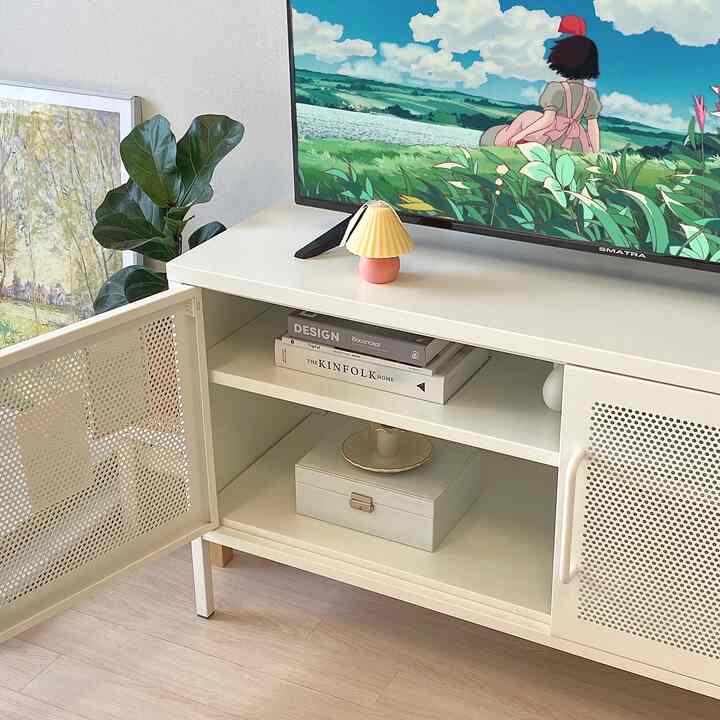 White-toned living room space featuring a Market B TV stand and a large plant, presenting a clean and practical design