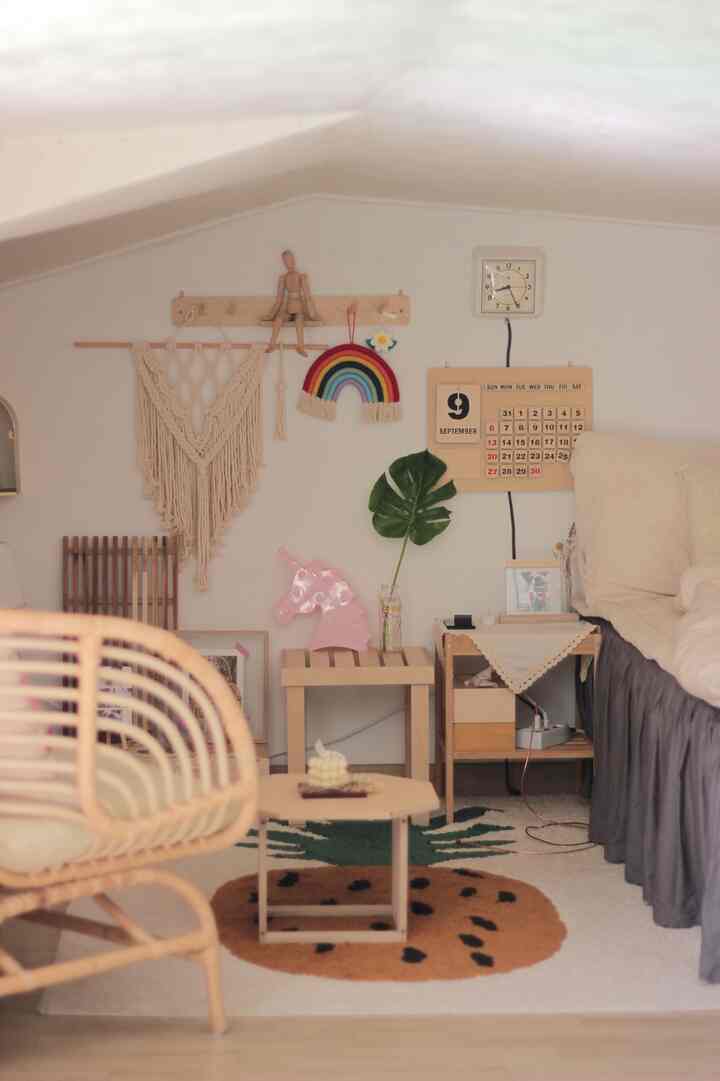 Natural wood-tone loft bedroom featuring a rattan armchair and pineapple-shaped rug with cozy atmosphere