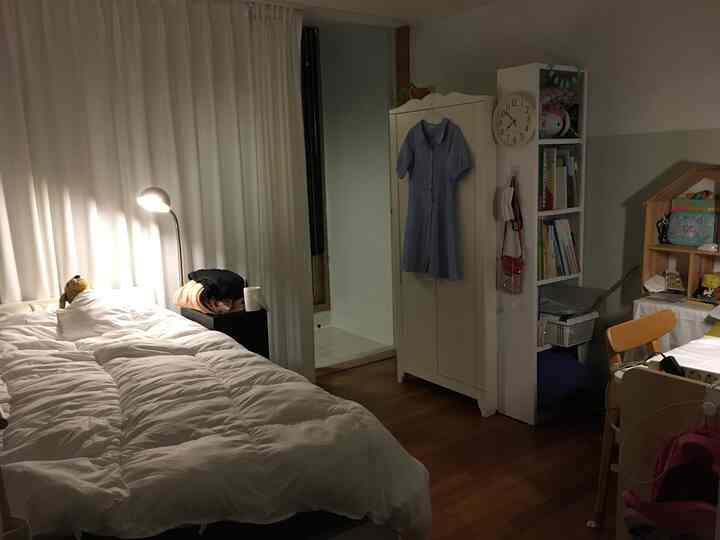 ホワイトと木目調が調和した子供部屋、ベッドやクローゼット、子供用デスクが配置された雰囲気のあるインテリア