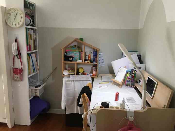 白と茶色のトーンの子供部屋、机と本棚、多様な収納が配された印象的な学習空間