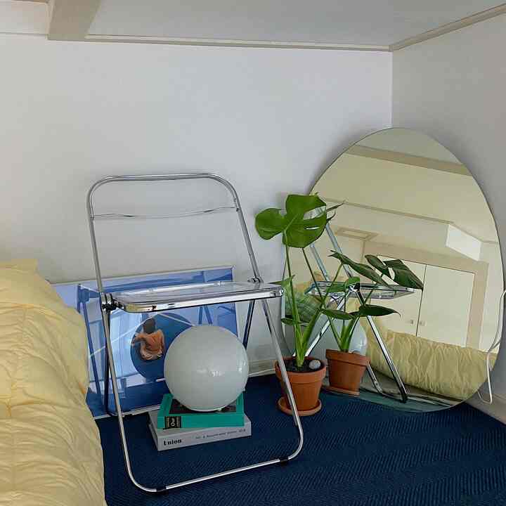 黄色い寝具と緑の植物が配置されたロフト寝室、モダンでナチュラルな雰囲気のインテリア