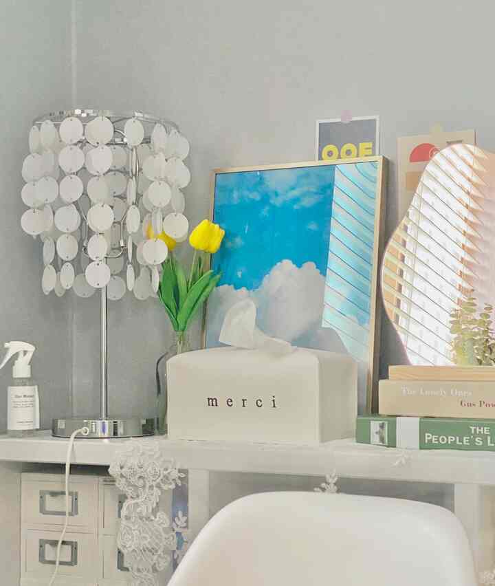 ホワイトとシルバーの色調の鏡と額縁が配置された落ち着いた室内空間、鮮やかなイエローのチューリップが自然なアクセントを添える