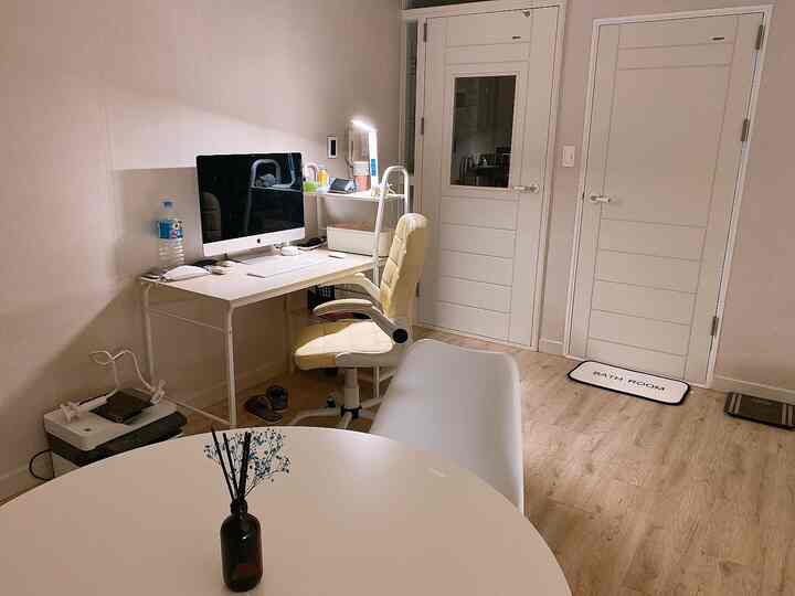 White and natural toned studio apartment home office space featuring a desk and office chair with a clean work environment