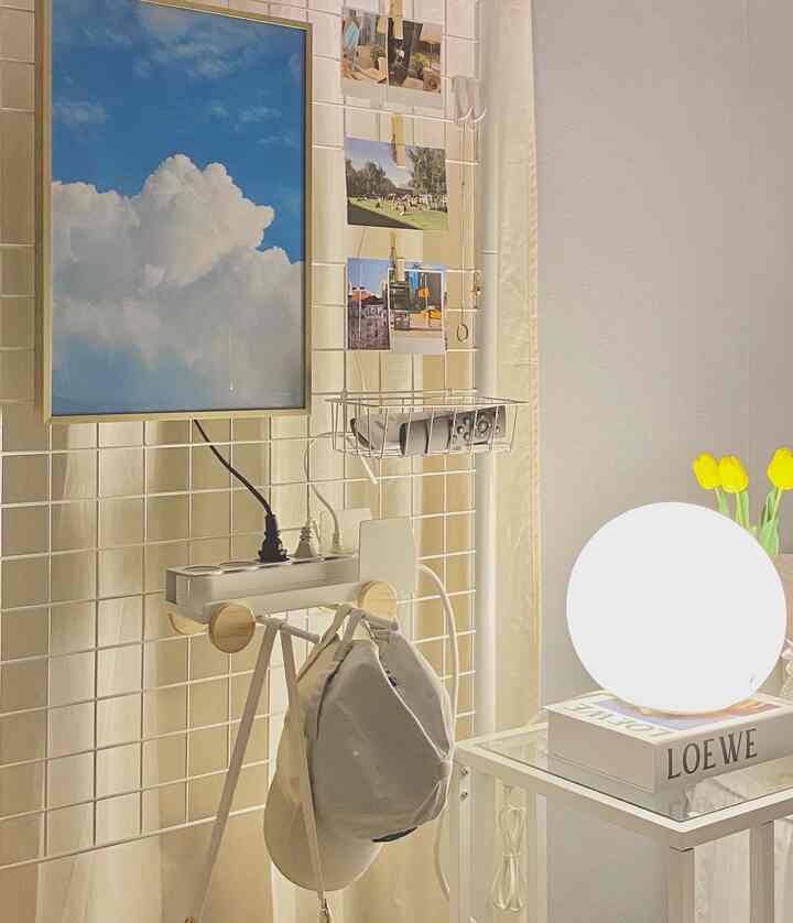 アイボリーのカーテンと白いメッシュボードのパーティションが配置されたモダンな空間、黄色のチューリップと丸いムードライトがアクセントの落ち着いた雰囲気