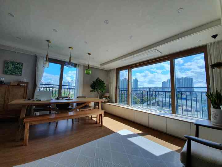 ナチュラルな木目調と大きな窓が特徴の明るいリビング兼ダイニングルームのインテリア