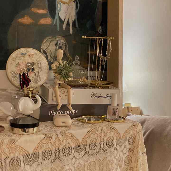 Natural-toned accessory storage space featuring gold trays and a wooden mannequin, creating a warm and organized interior