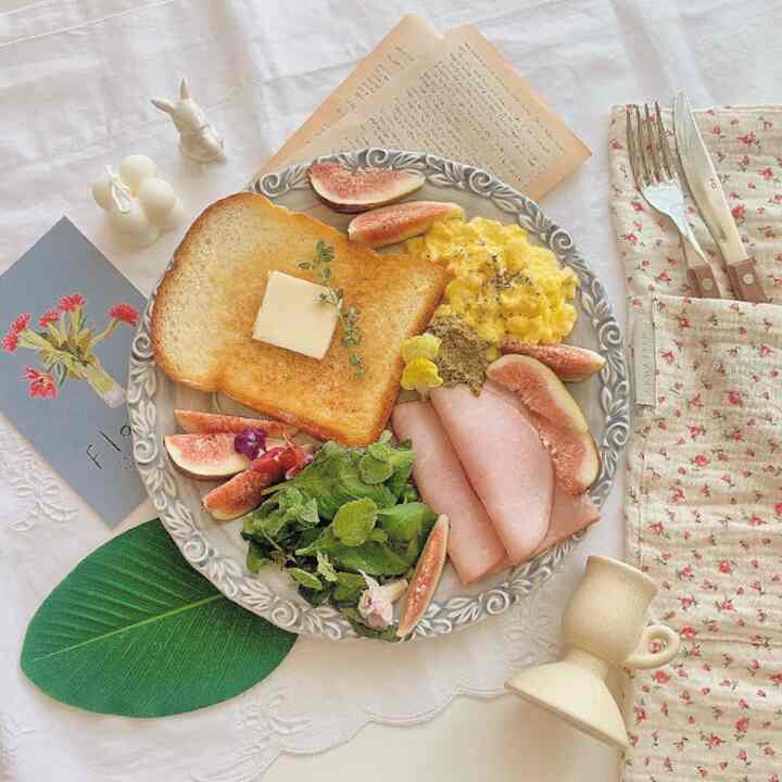 A cozy space with vintage-style plate and home cafe brunch plating on a white tone tablecloth
