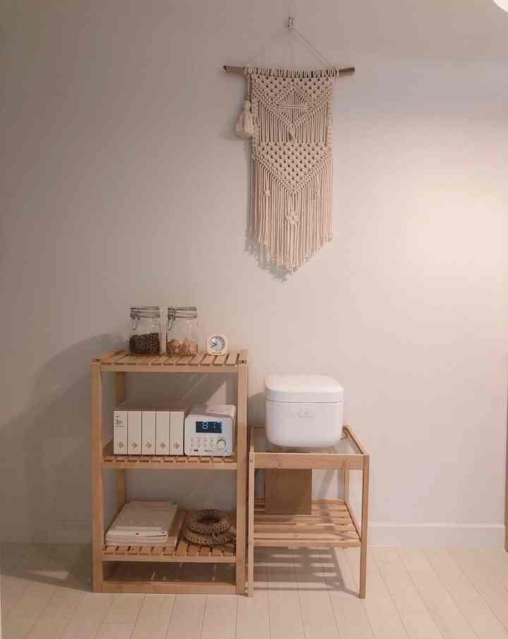 White-walled kitchen storage space featuring wood tone shelves with a minimal and clean atmosphere