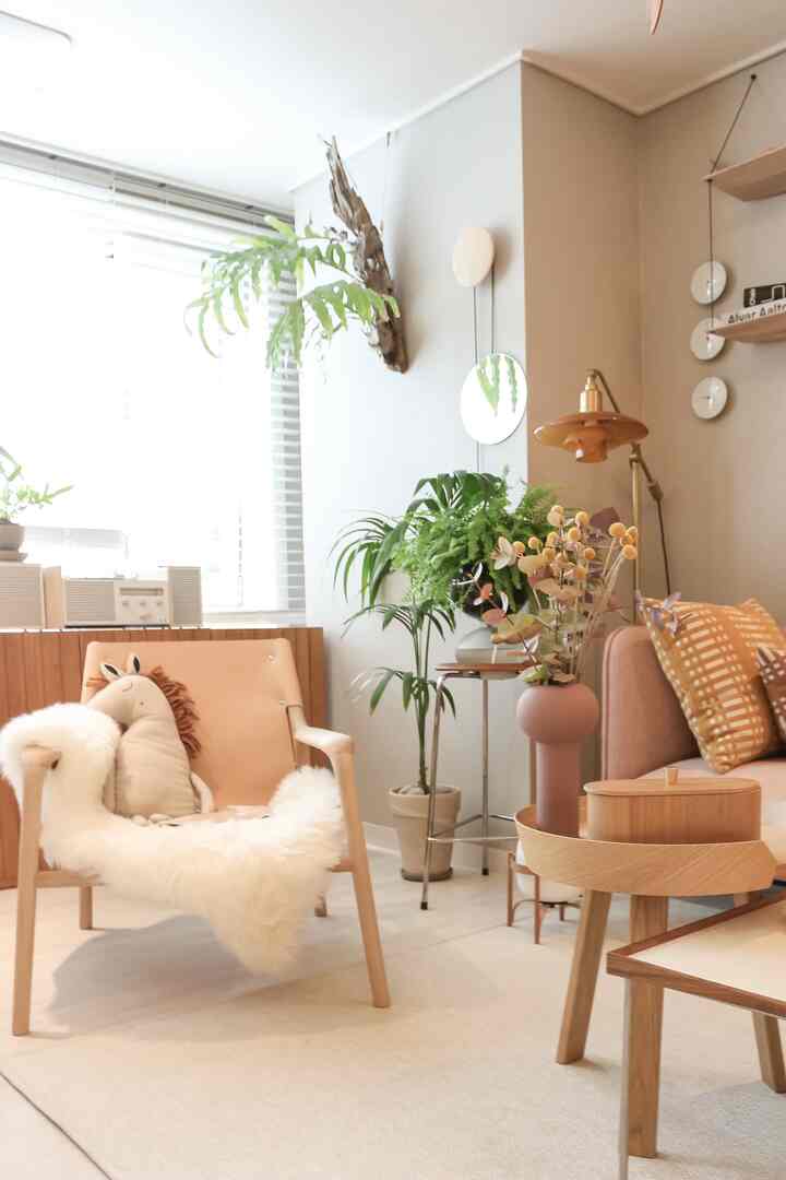 Natural wood-tone Nordic living room featuring lounge armchair, sofa, green plants, and cozy decor with warm ambiance
