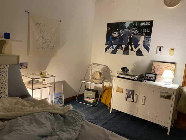 White and dark gray toned bedroom featuring vintage LP player and Beatles poster, creating a cozy retro atmosphere
