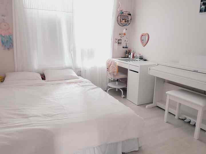 ホワイトトーンの女の子の子供部屋、ベッドとデスクが整然と配置された清潔でラブリーなインテリア